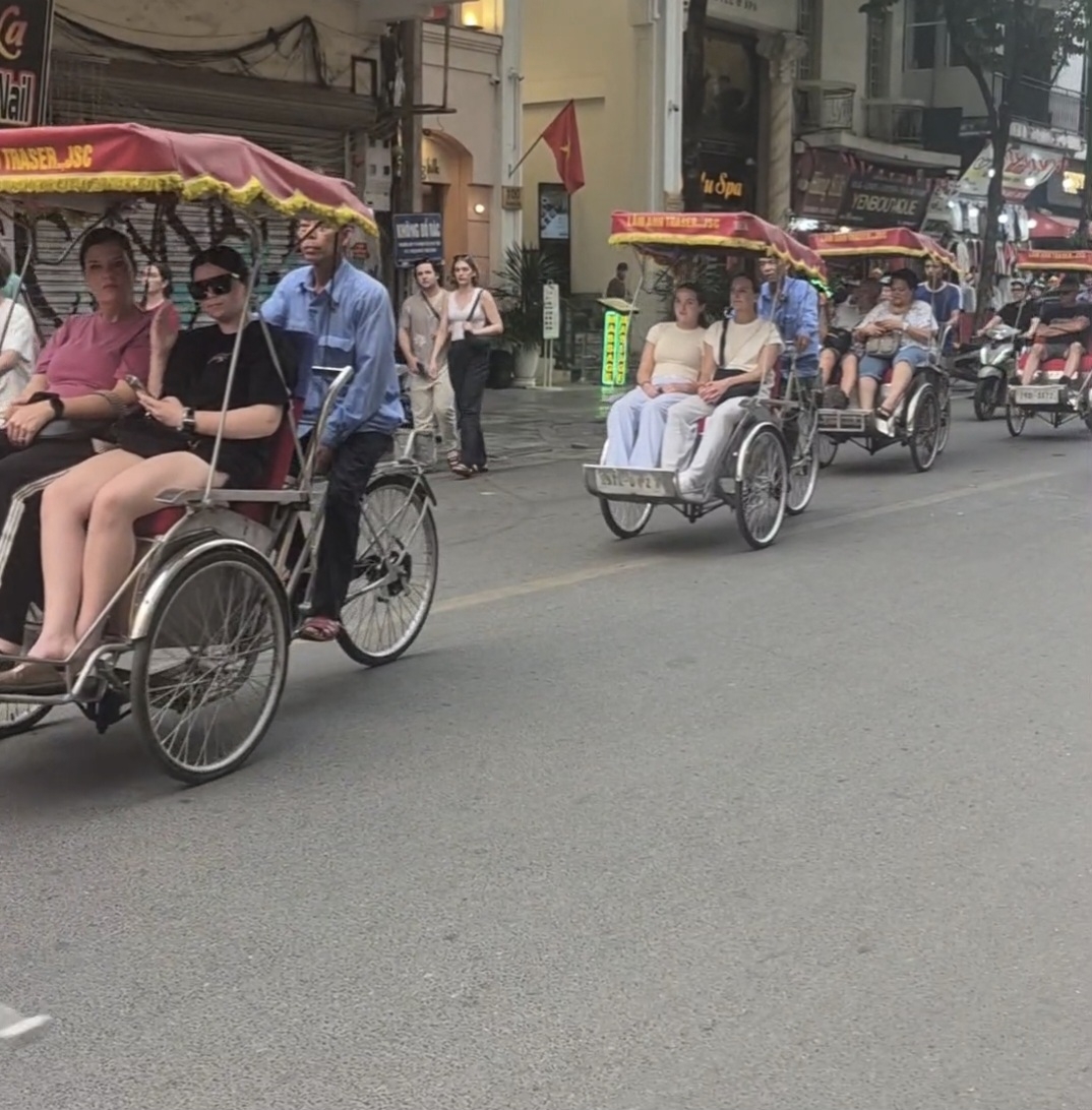 Tourists exploring the Hanoi Old Quarter by cyclo
